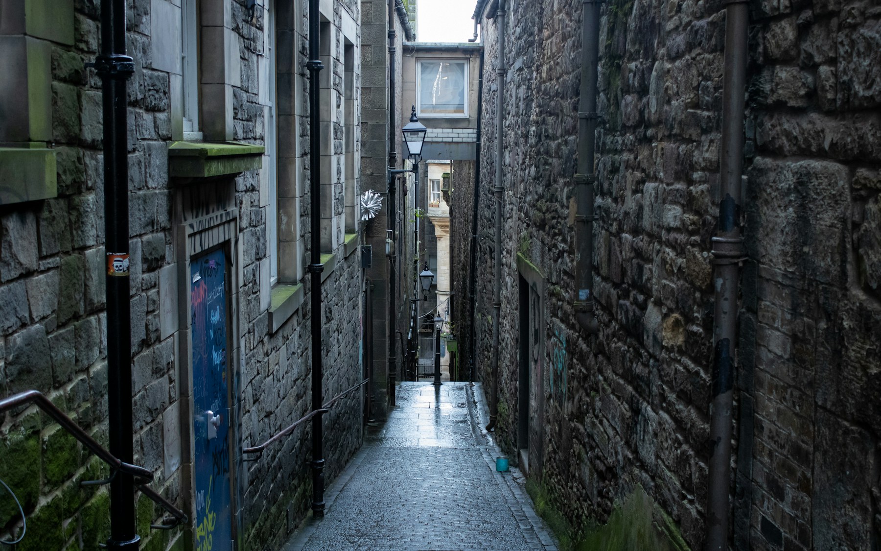 A narrow rain-wet stone close descending through Edinburgh’s Old Town